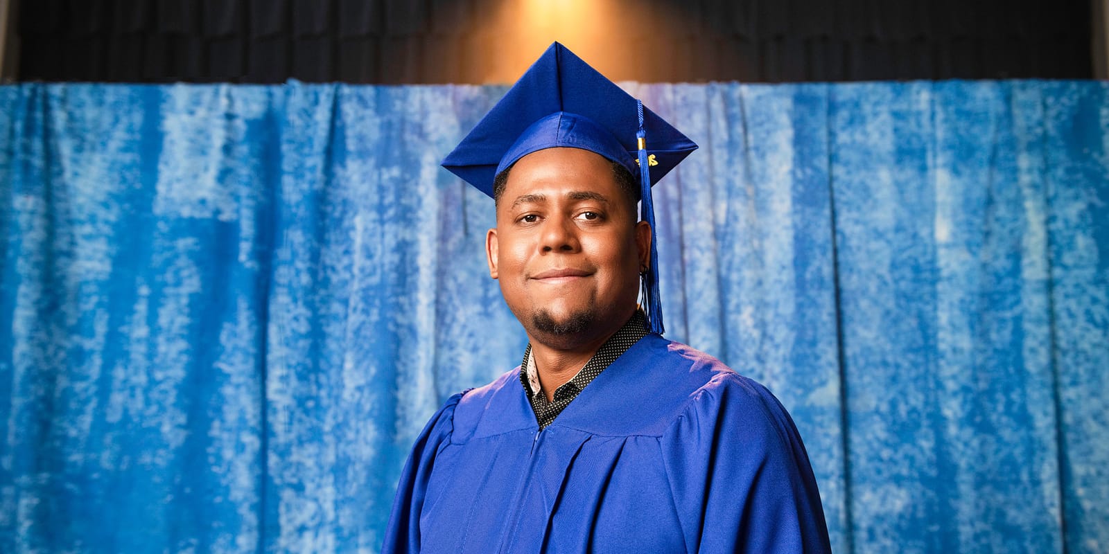 Man with a graduation cap smiling