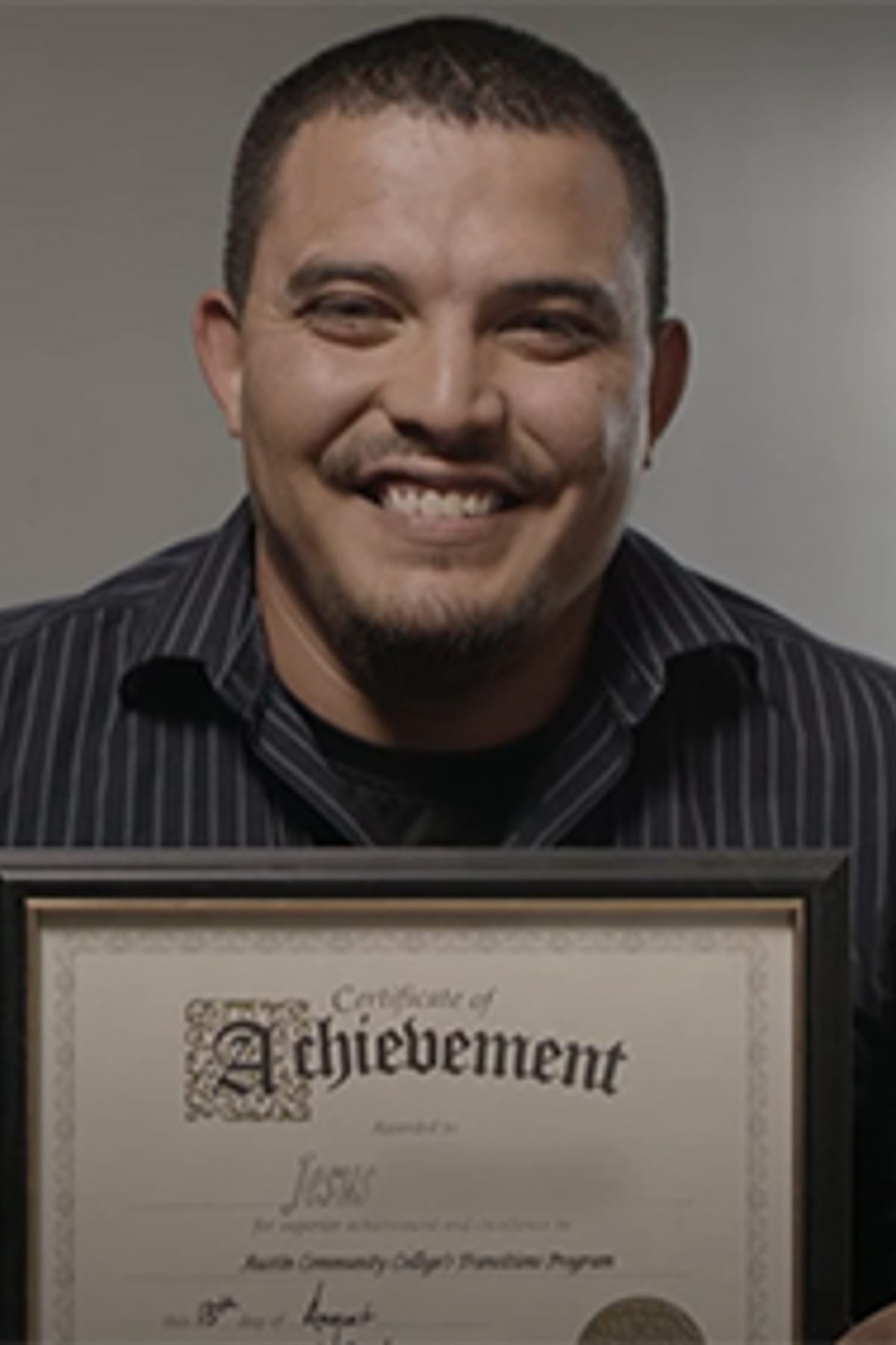 Man smiling with his high school diploma