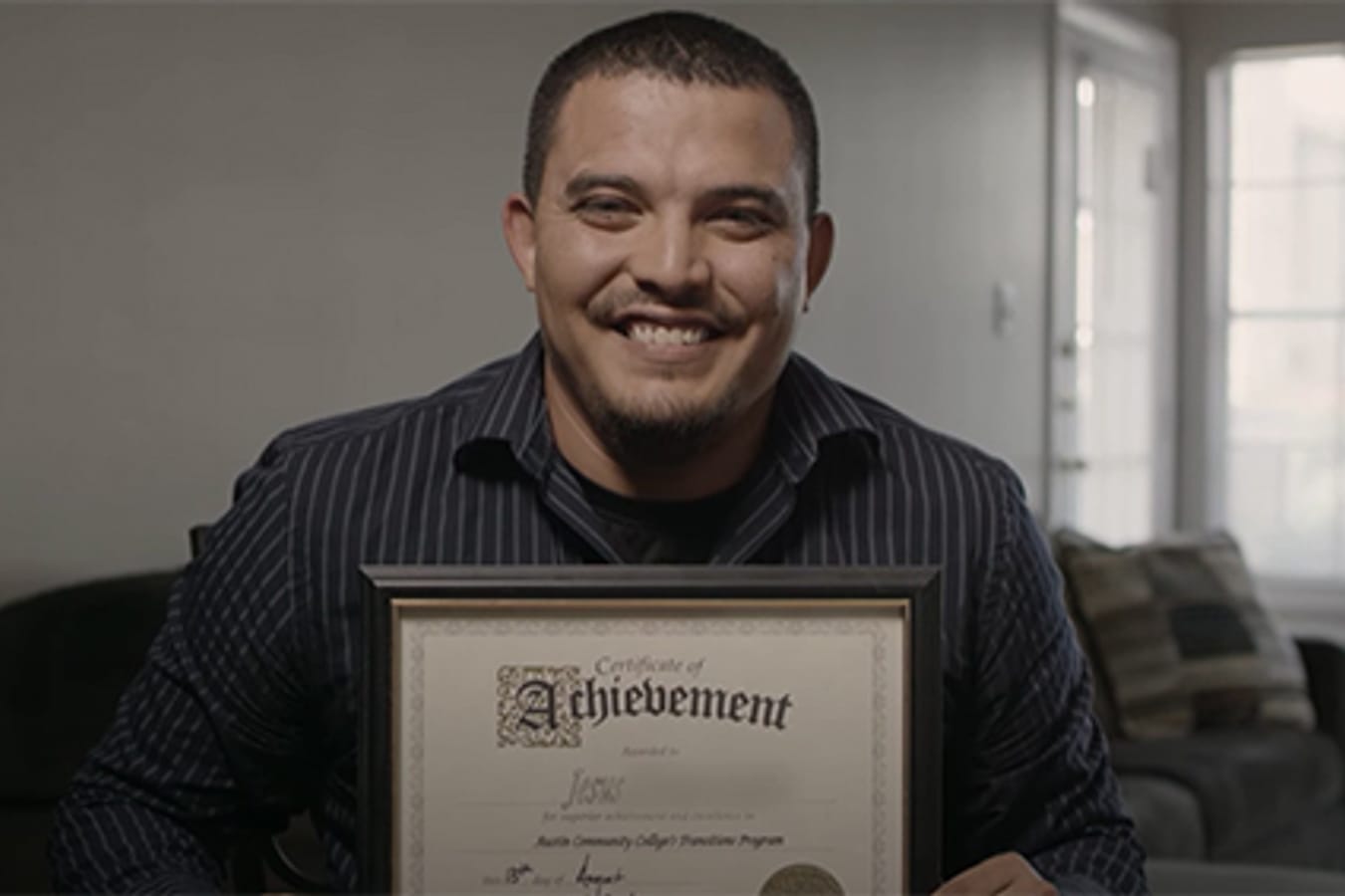 Man smiling with his high school diploma